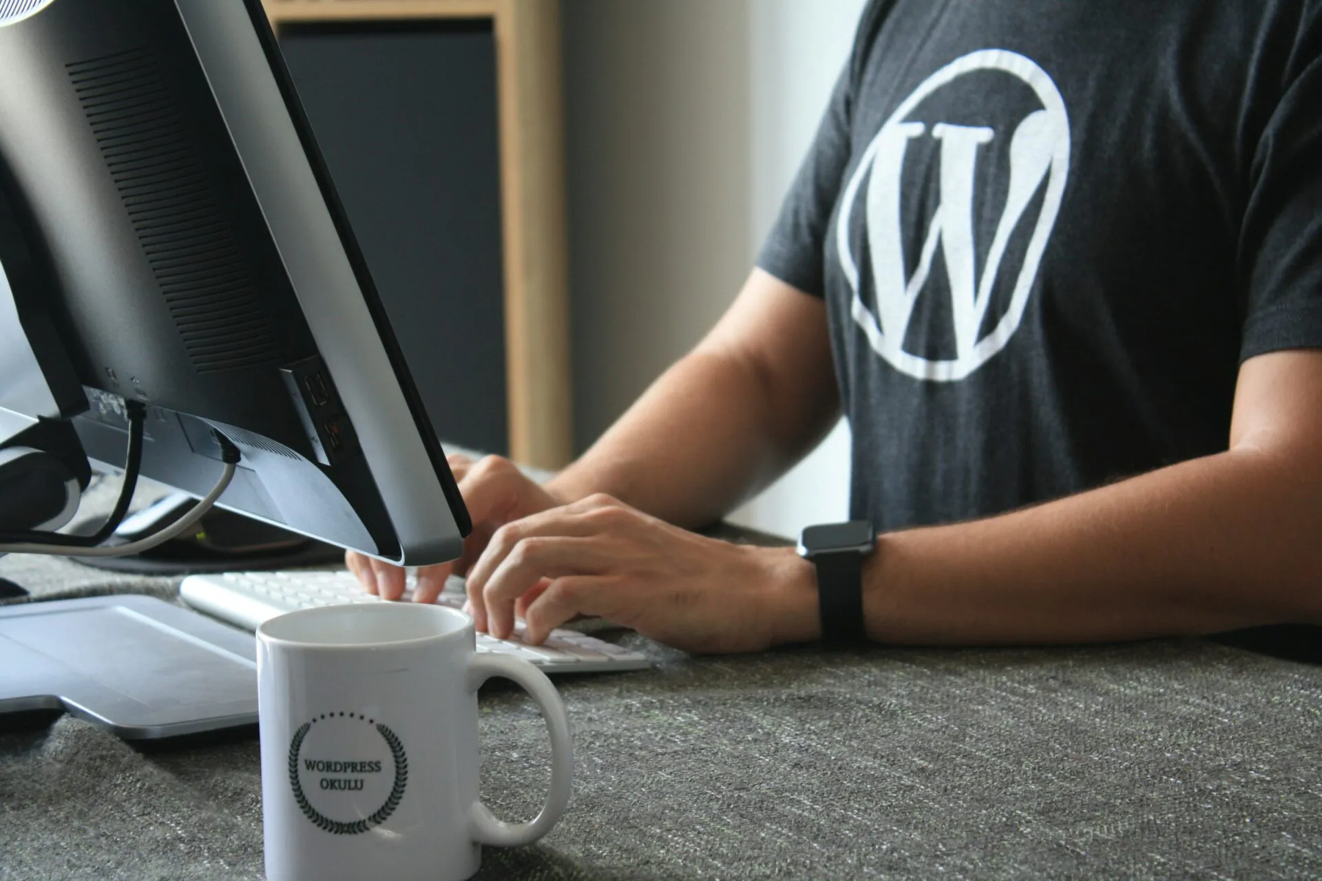 WordPress Entwickler aus Köln in einem schwarz-weißen T-Shirt am Computer